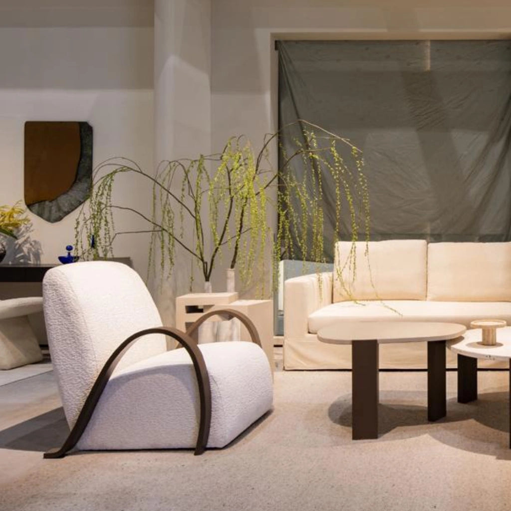 White upholstered armchair with curved dark wooden armrests in living area