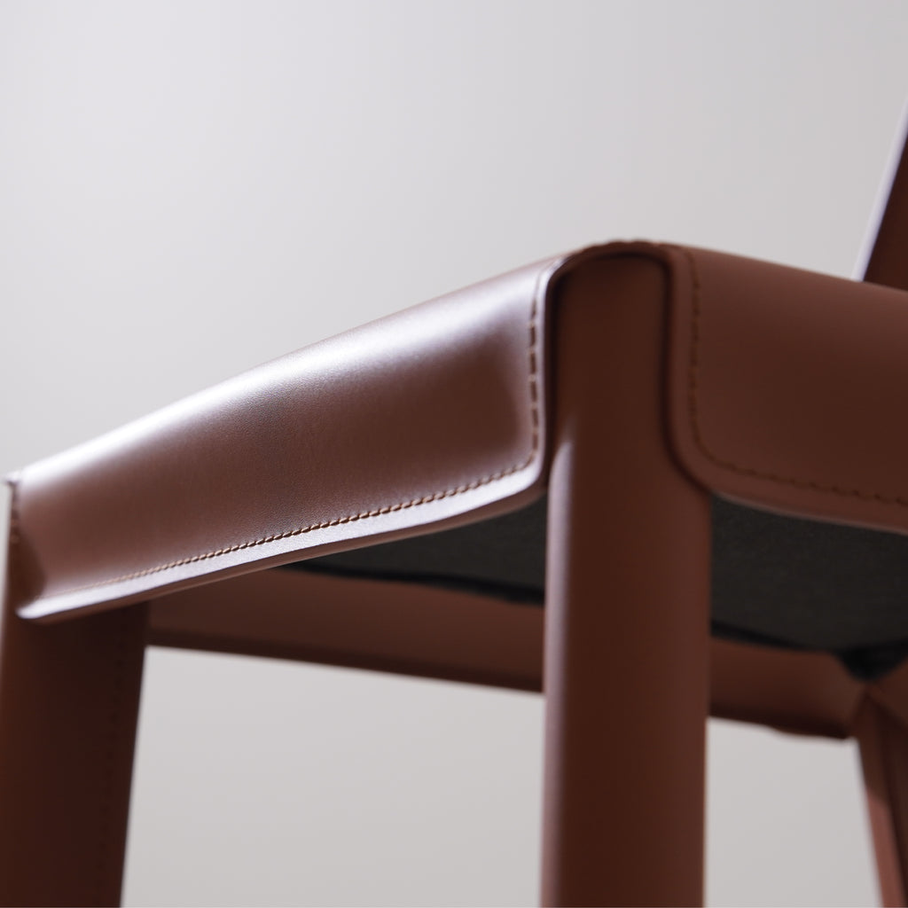 Closeup of brown saddle leather bar stool upholstered seat