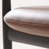 Close-up of brown leather upholstered padded seat on Brody Dining Chair