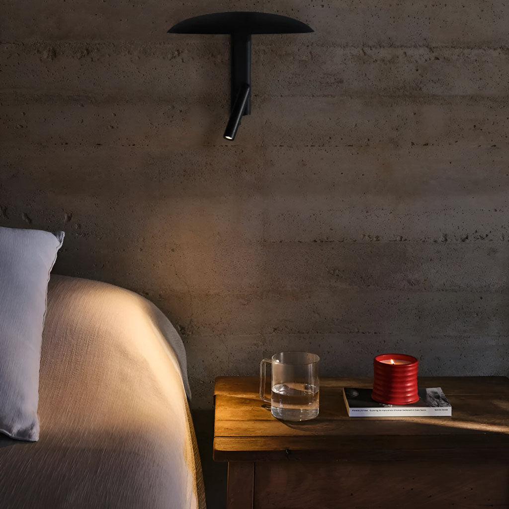 Unique wall light 360° adjustable ambient lighting in black steel for a cozy bedroom.