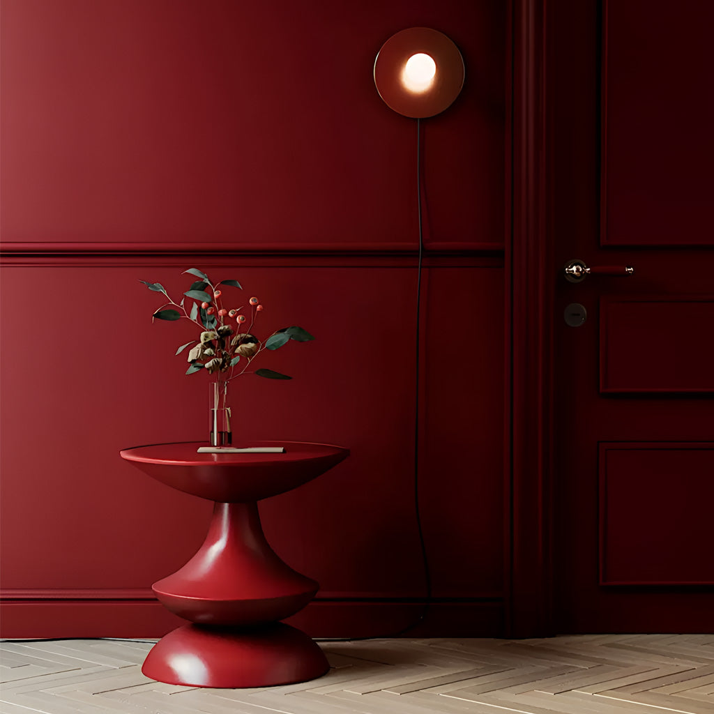 Unique and elegant round top side table in deep maroon red made from fiberglass