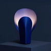 Deep blue steel table lamp, warm soft ambient light creates a moody tone.