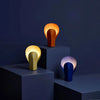 Modern art sculptural lighting design in yellow-gold, terracotta orange, and deep blue. Vibrant and playful designer lamps.