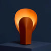 Nodo Table Lamp in terracotta orange steel, warm ambient light. Available in Malaysia.