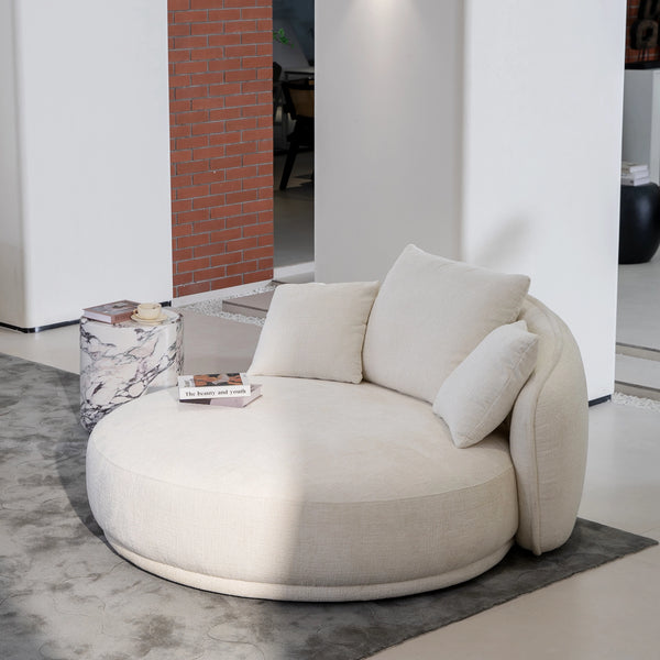 Round cream chaise lounge with soft cushions in modern interior