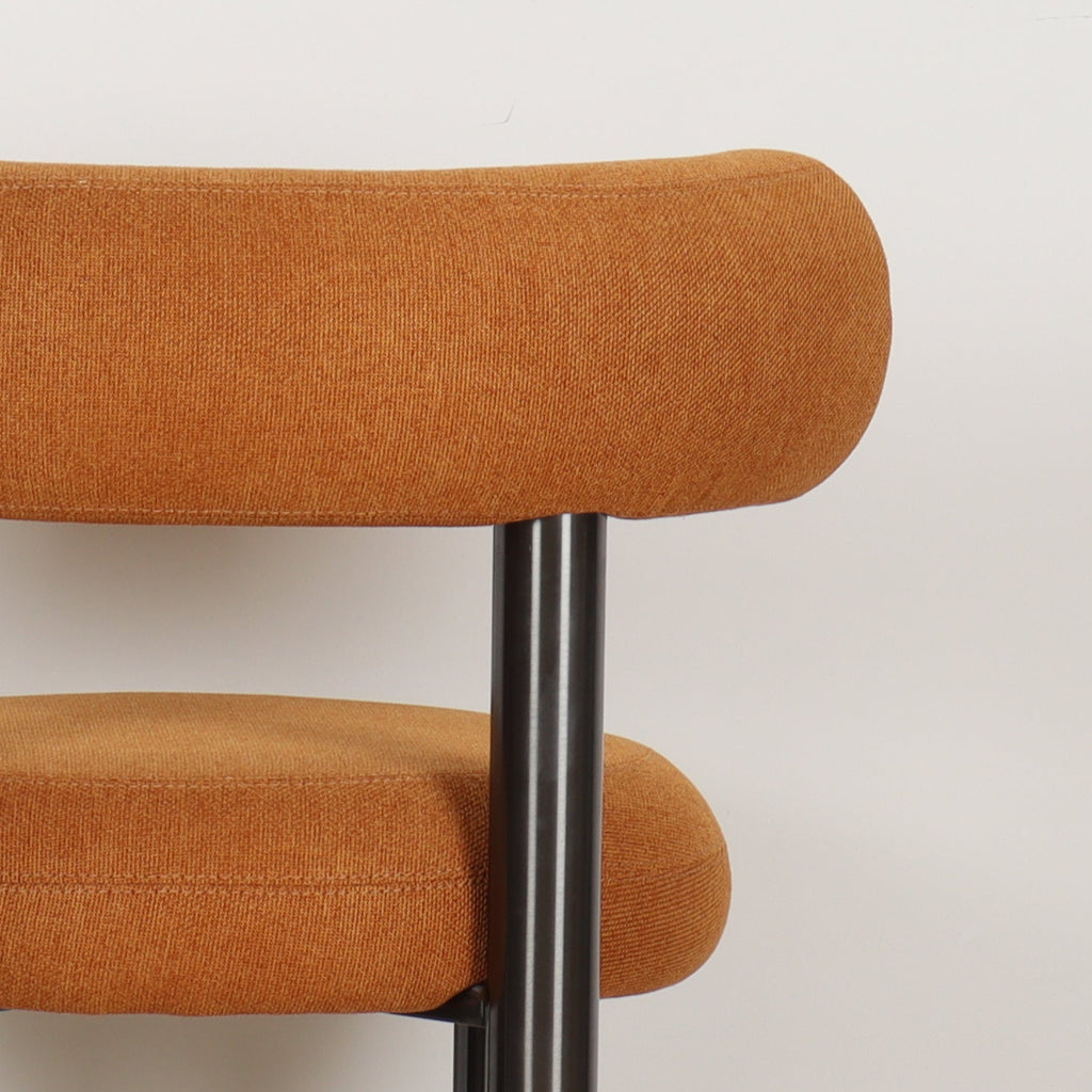 Close-up of ROLO dining chair's linen fabric in warm Caramel color
