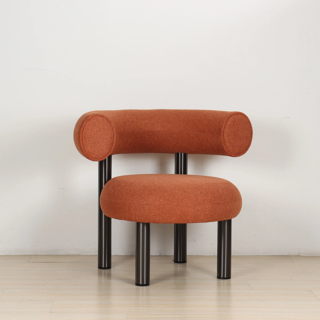 ROLO lounge chair in caramel photographed in a room, on slim tubular steel legs.