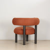 Rear view of the ROLO lounge chair showing the sculptural rolled thick cushioned backrest.