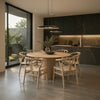 Six-seater RONAN round wood dining table with FISKBEIN woven seat chairs in a modern dark kitchen dining space.