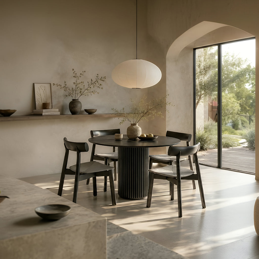 RONAN and IRIGUCHI four-seater black round dining set in a warm minimalist dining room with neutral walls.