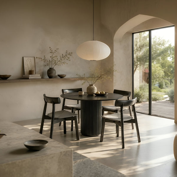 RONAN and IRIGUCHI four-seater black round dining set in a warm minimalist dining room with neutral walls.