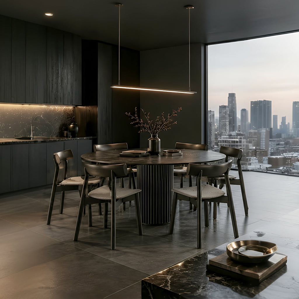Six-seater RONAN black round dining table with IRIGUCHI padded chairs in a modern dark kitchen and dining space.